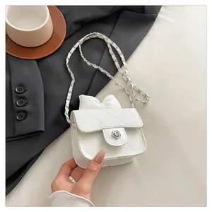 Detail of white quilted mini bag with camellia flower clasp and leather chain strap