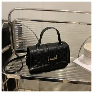 Détail du sac à bandoulière noir en similicuir matelassé avec fermoir rotatif en métal