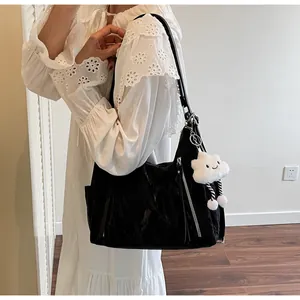 Dettaglio borsa hobo nera lucida plissettata con zip argento e ciondolo a nuvola