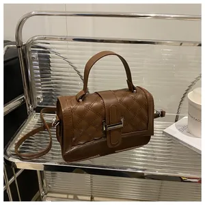 Détail du sac à bandoulière matelassé marron avec fermoir rotatif argenté et support