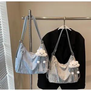 Détail de sacs fourre-tout bleu clair et gris argenté avec breloques nuages en peluche
