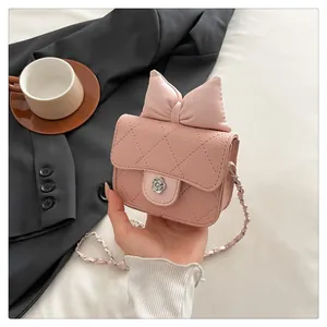 Detail of light pink quilted bag featuring a bow and silver camellia metal clasp