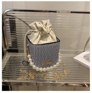 Detail der karierten Beuteltasche mit großem Perlenriff und goldener Kette