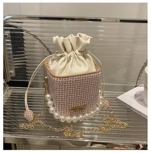 Detail der karierten Beuteltasche mit Perlenriff, Kordelzug und goldener Kettenriemen