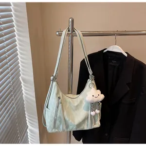 Détail du sac en nylon vert menthe plissé avec fermetures éclair et breloque nuage
