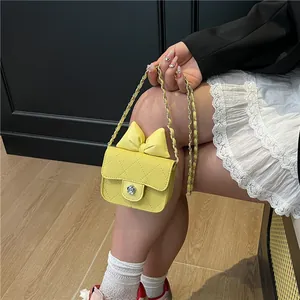 Petit sac matelassé jaune avec nœud et fermoir fleur, porté par un mannequin en dentelle