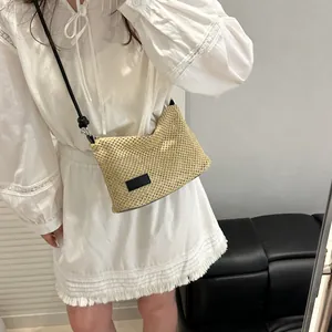 Petit sac à bandoulière minimaliste en paille tissée avec logo noir et sangle