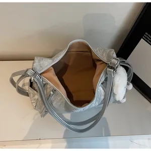 Dettaglio dell'interno della borsa argento metallizzato con tasca a zip e fodera marrone