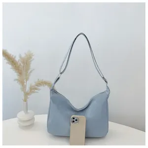 Detailed view of light blue hobo bag capacity compared with a smartphone