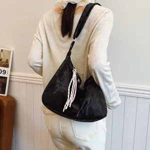 Detailed view of large black hobo shoulder bag with stylish woven rope decoration