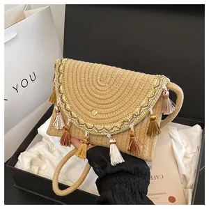 Detailed straw woven bag with colorful fringe tassels and ethnic embroidery in a gift box