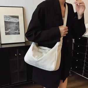 Chic off-white suede hobo shoulder bag with crescent silhouette and wide strap