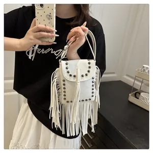 Detalle del bolso blanco con flecos con remaches vintage y borlas largas de cuero