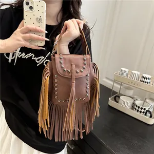 Bolso cuadrado de cuero marrón con remaches plateados y detalles de flecos
