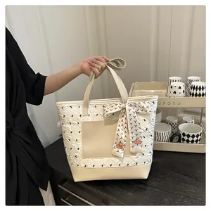 Close-up of white bubble fabric tote bag with leather pocket and decorative scarf detail
