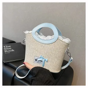 Détail du sac en paille avec poignée en cuir bleu clair, dentelle et nœud décoratif