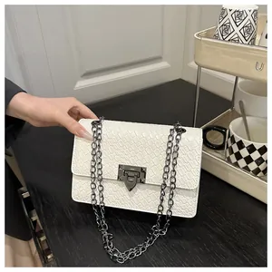Detail of white woven texture shoulder bag with gunmetal square lock and chain strap