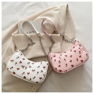 Detailed macro view of cherry print PU leather and gold chain strap on shoulder bag