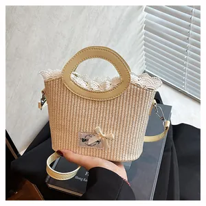 Détail du sac seau en paille avec bordure en dentelle, nœud et poignées rondes en cuir