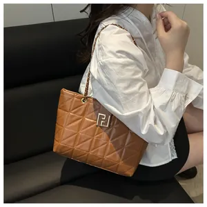 Detailed view of brown quilted handbag featuring gold F-buckle and chain strap
