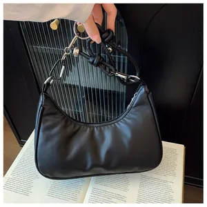 Détail du sac hobo demi-lune noir montrant la chaîne à anneaux et la bandoulière nouée