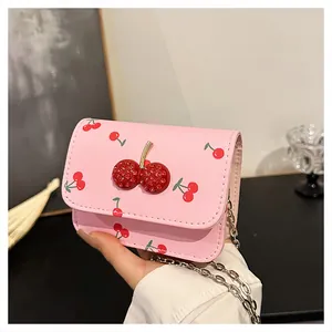 Detailed shot of pink crossbody bag featuring 3D beaded cherry and silver chain