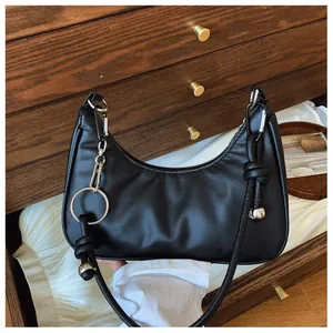 Gros plan du sac hobo noir avec anneau argenté, détail de nœud et pendentif sphérique