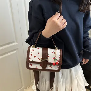 Fresh white mini square handbag with red cherry print and contrast brown leather trim