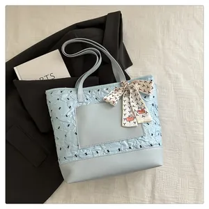 Close-up of light blue pleated tote bag featuring leather patchwork and silk scarf detail