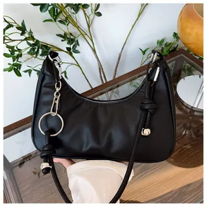 Détail du sac hobo noir avec anneau argenté et bandoulière à nœuds décoratifs élégants