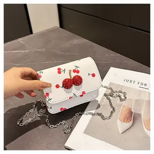 Close-up of white leather bag with cherry print and 3D rhinestone cherry decoration