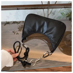 Détail du sac demi-lune noir en cuir mat montrant les finitions métalliques argentées