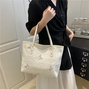 White quilted tote bag with colorful butterfly embroidery and long leather shoulder straps