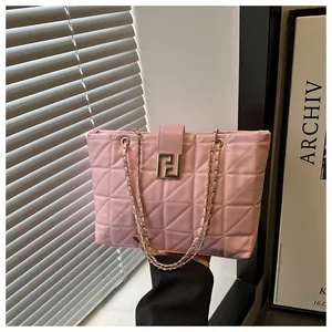Detail of pink quilted tote bag with gold chain strap and geometric metal buckle