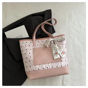 Detail of pink pleated tote bag with black bows and decorative printed silk scarf handle