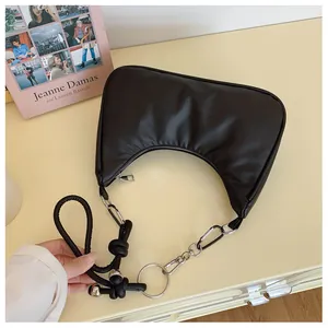 Détail du sac hobo en croissant noir avec anneau métallique et bandoulière en cuir noué