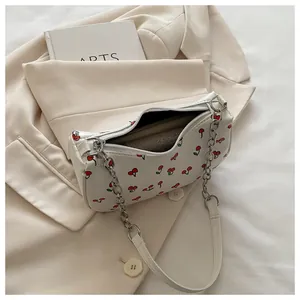 Detail of white cherry print handbag with silver chain strap and zipper closure