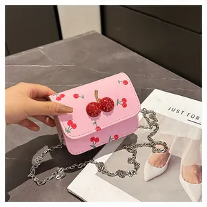 Detailed view of pink cherry print bag featuring a 3D crystal cherry buckle and silver chain
