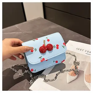 Close-up of mini cherry print crossbody bag with 3D rhinestone cherry and silver chain