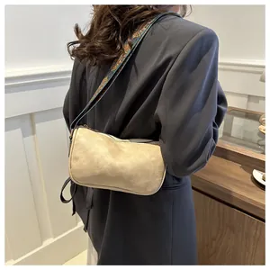 Detail van beige vintage schoudertas met kleurrijke etnische riem en getextureerde afwerking