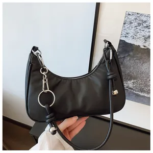 Détail du sac à bandoulière noir en forme de croissant avec des ferrures argentées
