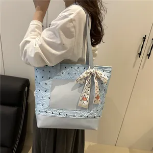 Stylish light blue quilted tote bag with black bows and decorative scarf for women