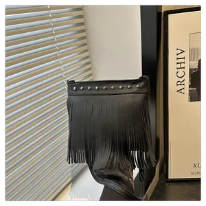 Detalle de bolso bandolera negro con tachuelas plateadas y flecos largos de moda
