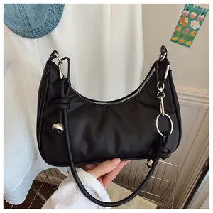 Détail d'un sac demi-lune noir avec une bandoulière nouée et des finitions en métal argenté
