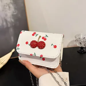 White square crossbody bag with red cherry patterns and sparkling cherry clasp with chain