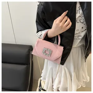 Dettaglio borsa in camoscio rosa con fibbia quadrata di strass e catena dorata