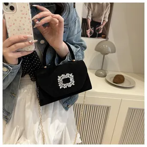 Dettaglio macro dell'elegante fibbia quadrata con strass sulla borsa in velluto nero