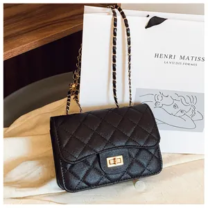 Detailed macro view of black quilted leather texture and golden metal rotary lock