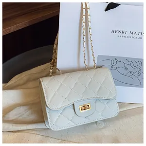 Close-up of beige quilted leather handbag featuring a golden turn-lock clasp and chain strap