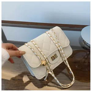 Close-up of cream quilted crossbody bag with gold chain strap and metal lock detail